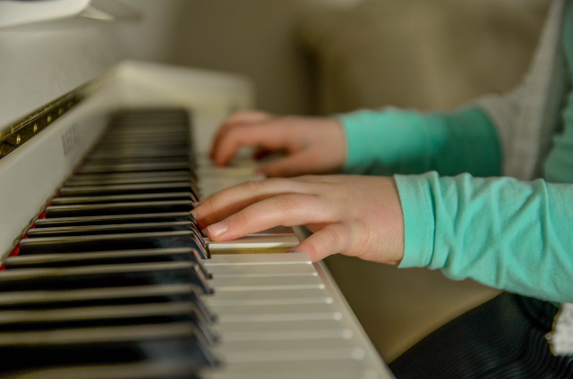 Imágen de las manos de un niño al piano